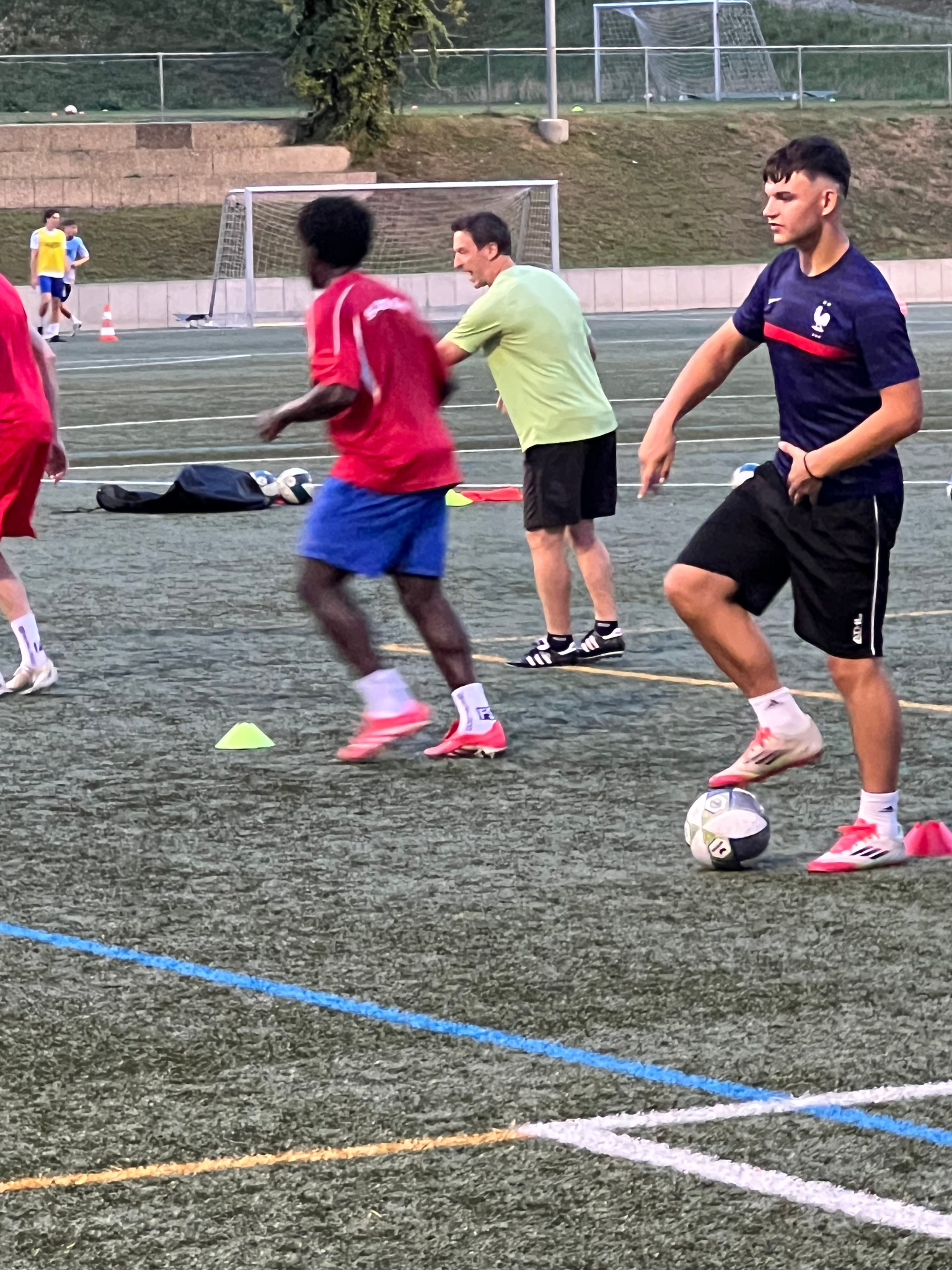 Training auf dem Fussballplatz mit Spielern und einem Coach